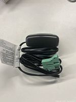 Photo of black 6V charger with long cable and green connector, showing manufacturer tag.