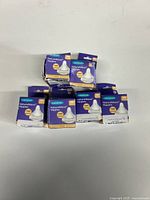 Seven boxed sets of Lansinoh Natural Wave Nipples stacked showing product packaging.