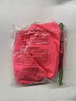 Pink costume set folded and sealed in clear plastic packaging with warning labels visible.
