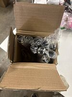 Box with multiple wrapped aluminum curtain rods inside, showing the quantity packed and packaging condition.