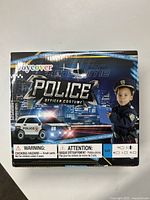 Front of box showing child wearing the police costume set and branding information