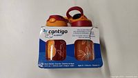 Front view of Contigo Aubrey water bottles set, showing red and orange bottles with white floral pattern and packaging label.