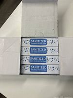Opened box showing multiple smaller boxes labeled 'SANITIZED FOR YOUR PROTECTION'.