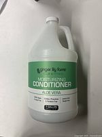 Front view of 1 gallon jug of Ginger Lily Farms moisturizing conditioner with aloe vera showing product labeling.