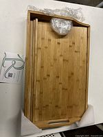 Top-down view of the bamboo bed tray showing the natural bamboo finish, handle cutout, raised edges, and wrapped phone holder area.