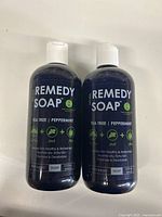 Front view of two Remedy Soap bottles showing brand, scent (Tea Tree Peppermint), and volume (13.5 fl oz each).