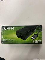 Box top showing Puning branding and power adapter image with voltage and current specs