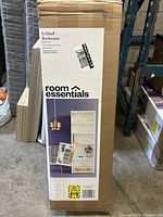 Boxed room essentials 5-shelf white wood bookcase with product details.