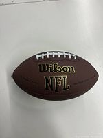 Brown leather Wilson NFL football showing front side with logos and white laces.