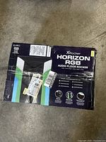 Box of X Rocker Horizon RGB Audio Floor Rocker gaming chair showing the front packaging with product name and features