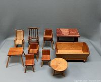 Nine wooden doll house furniture pieces arranged on a gray background: includes armchairs, high chairs, small chairs, side tables, a round table, and a couch.