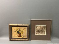 Two framed artworks: oil painting of yellow flowers and forest etching, displayed side by side.