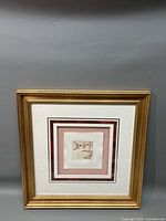 Full view of framed hummingbird etching against gray background.