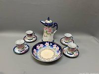 Full set including coffee pot, bowl, four cups and four saucers displayed together.