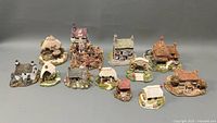 Set of 12 miniature Lilliput Lane cottages displayed in rows on gray background
