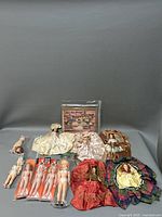Full display of dolls including dressed and undressed Lingerie Lou dolls and other small dolls with packaged outfit patterns behind them.