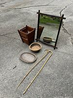 Overview of all items on ground: the framed mirror, two wooden canes, and three woven baskets