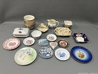Full view of all porcelain items arranged on a table, showing varied sizes and styles including serving dishes, plates and bowls.
