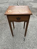 Front view of the wooden one drawer end table showing drawer and legs.