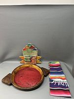 Photo showing all three items side by side: southwestern sculpture, wooden tray, and serape scarf.