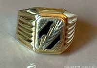 Front view of ring showing rectangular face with black enamel inlay and engraved detailing