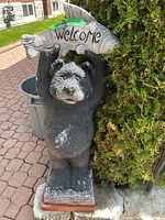 Front view of entire sculpture showing bear, fish sign, and base