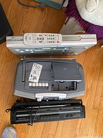 Top-down view of LiteOn DVD recorder with remote on top, Sony SCR-200 radio cassette recorder beneath, and Sony CFD-V8 CD radio cassette recorder below both units, all stacked on wooden floor.