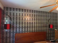 Full room view showing both wall lamps mounted on patterned wall above headboard