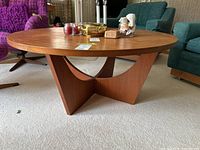 Angled front-left view showing round tabletop surface and pedestal base design.