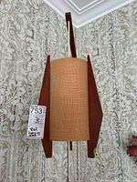 Front view of the teak hanging lamp with burlap shade