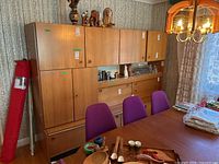 Front left view of entire wall unit and buffet alongside dining chairs and table