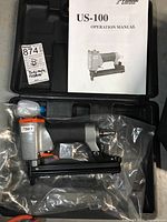 Case open showing nailer, manual and label