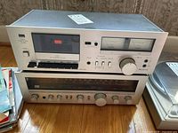 Front view of vintage Sansui cassette deck D-90 stacked on top of Sansui receiver R-50, showing cassette controls, VU meters, tuning dial, and control knobs.