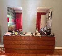 Full front view of teak dresser with two mirrors and personal items on top