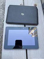 Front view of BlackBerry PlayBook tablet beside sleeve