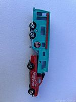 Turquoise camper trailer and red pickup truck with Coca-Cola branding