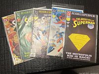 Group shot of six bagged Superman comics