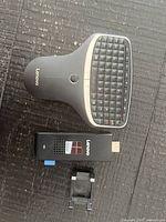 Front view of keyboard remote, HDMI stick, and mounting bracket