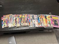 Stack of roughly thirty bagged comic books laid out on table