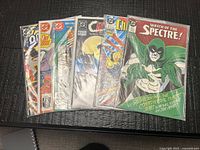 Group shot of six bagged DC comic books fanned on table