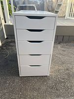 Front view of five-drawer white chest