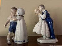 Front and side view of two porcelain figurines: a girl in white dress leaning to kiss a boy in blue shorts, and a young couple with the boy dipping the girl in dance.