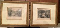 Two professionally framed prints side by side with gold-tone frames and white mats, showing detailed landscape scenes.