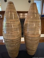 Pair of tall bamboo lacquered vases side by side showing their shape and finish.