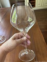 Single Riedel red wine glass held in hand showing wide bowl and stem