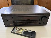 Front angle of Denon AVR-3200 receiver with remote control in front.