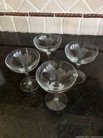 Set of 4 clear glass champagne or espresso martini glasses on a dark countertop, showing shape and size