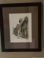 Framed sepia toned photograph of house fronts on a steep street, showing overall framed artwork and composition.