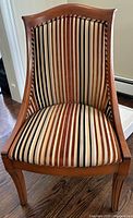 Front view of occasional chair showing striped velvet seat and wooden frame.