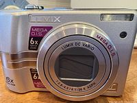 Front view of the silver Panasonic Lumix DMC-LZ6 camera highlighting the lens with 6x optical zoom and MEGA O.I.S.